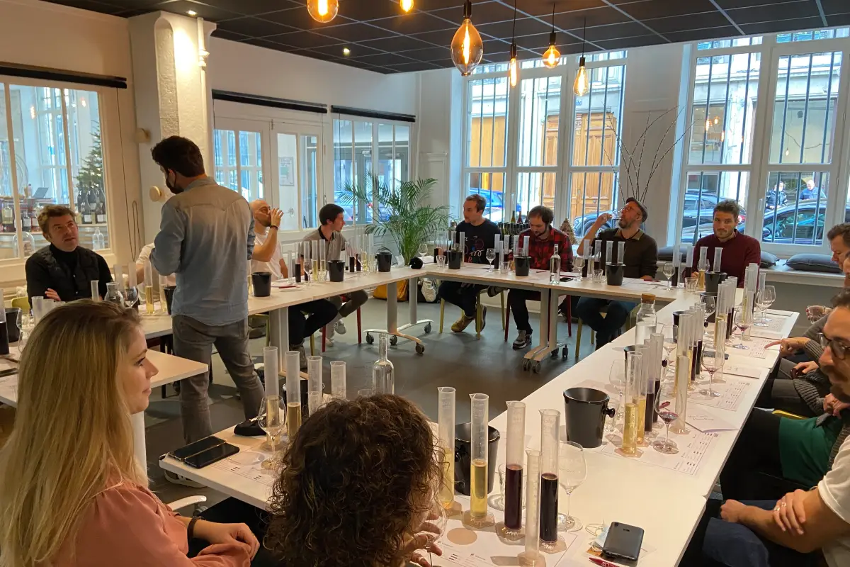 Personnes assistant à un atelier d'assemblage de vin dans un chai urbain à Lyon avec Atripik.